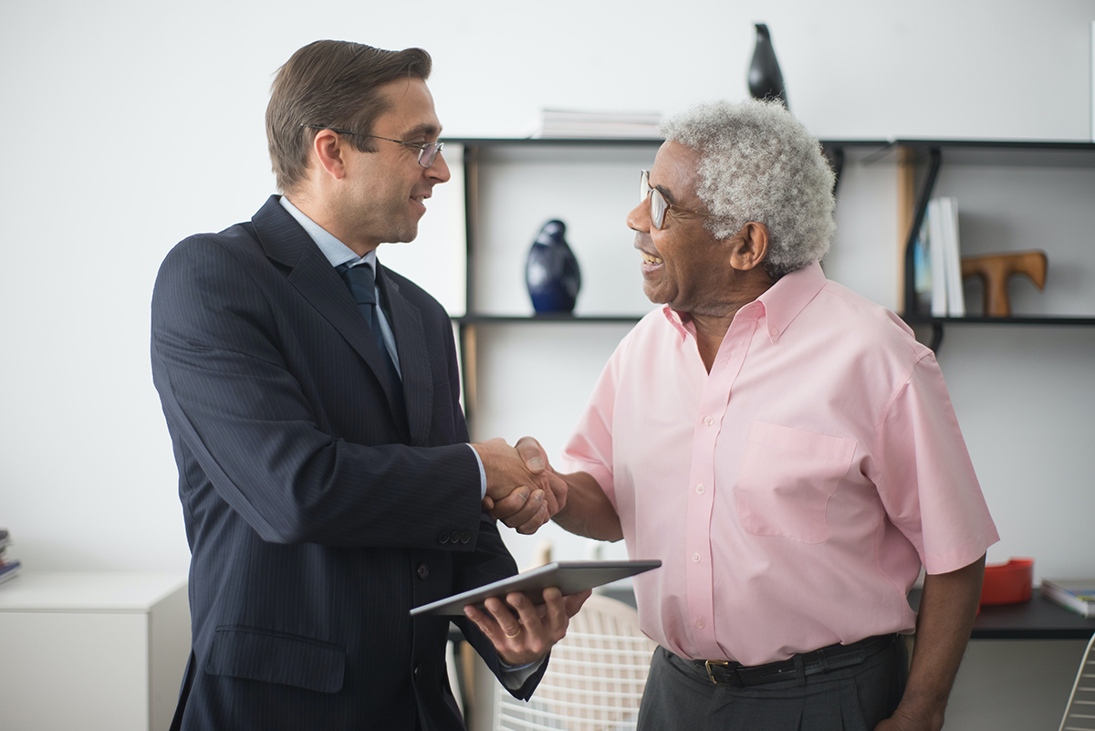 two men shaking hands and smiling as they make a deal