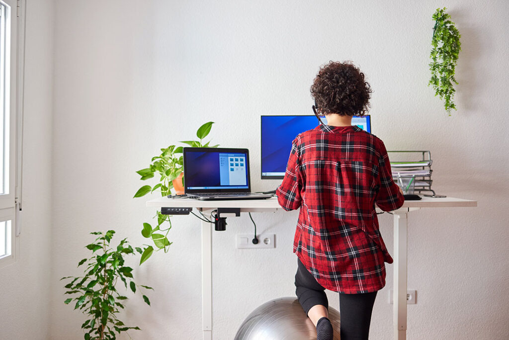 Woman working at her sit and stand adjustable height office desk.